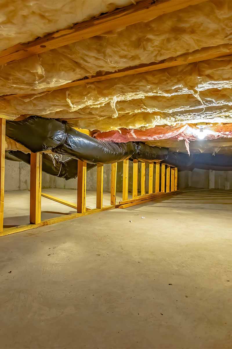 crawl space with light and hanging insulation