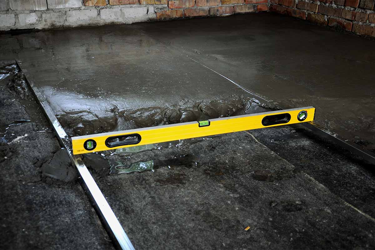 Leveling tool showing uneven concrete floor
